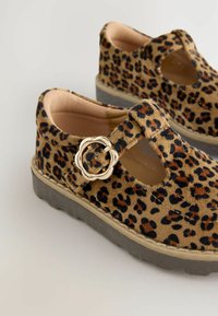 Chaussures à imprimé léopard en tissu doux ; dotées d'une boucle ronde sur une sangle et d'une semelle en caoutchouc épaisse de couleur grise, avec des côtés découpés.