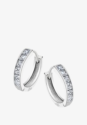 Boucles d'oreilles en argent en forme de créole, ornées d'une rangée de sept pierres en zircon cubique transparent rectangulaires le long d'un bord. Finition en métal lisse.