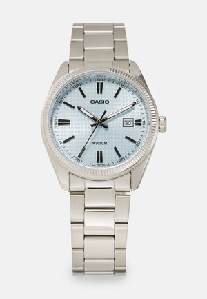 Strieborné nerezové hodinky s svetlomodrým textúrovaným ciferníkom, čiernymi hodinovými značkami a zobrazením dátumu. Vodoodolné do hĺbky 50 metrov.