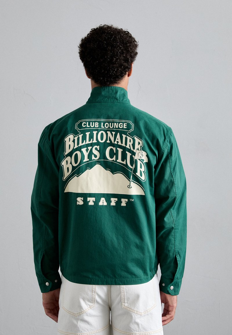 Grünes Baumwollhemd mit einem großen weißen Grafikdruck auf der Rückseite, der den Text "Billionaire Boys Club STAFF" und ein Bergdesign zeigt.