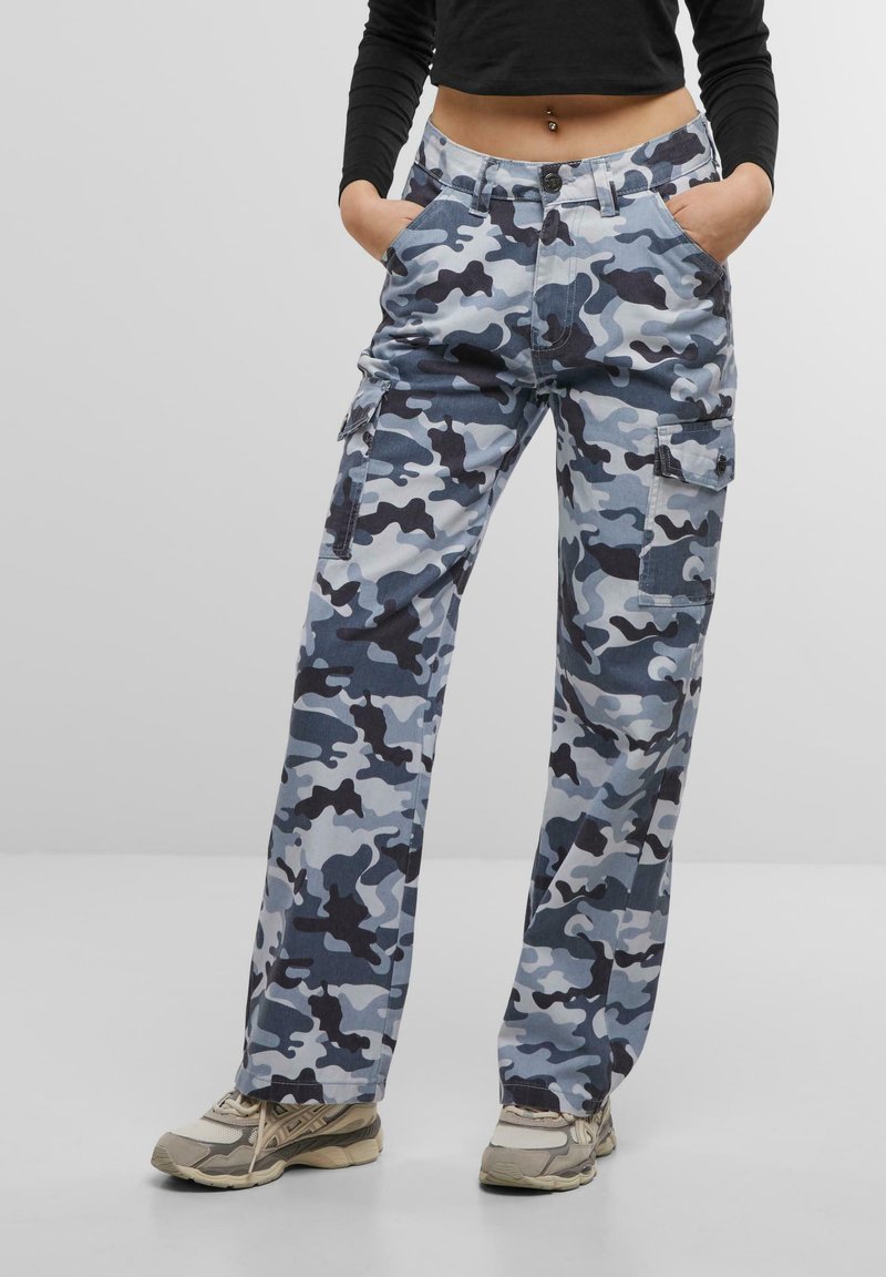 Pantalones cargo en un patrón de camuflaje azul y gris; cuentan con bolsillos laterales, un corte relajado y una tela resistente con una textura suave.
