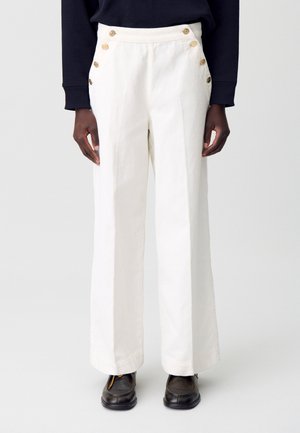 Pantalons larges blancs en tissu texturé, dotés de six boutons en laiton sur le devant et d'une taille haute.