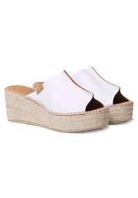 Sandales espadrilles à plateforme ouvertes blanches avec une semelle en jute tissé naturel et des accents en cuir marron le long du bord.