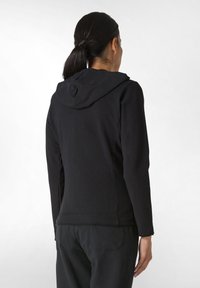 Felpa nera con design aderente, maniche lunghe e cappuccio. Realizzata in tessuto morbido, presenta una superficie liscia e dettagli nei pannelli laterali.