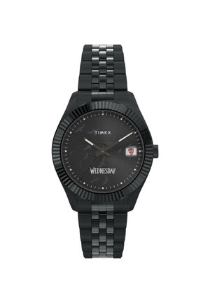 Orologio Timex in metallo nero con quadrante nero testurizzato, indicatori delle ore argentati e display del giorno con un accento a forma di teschio. Bracciale a maglie regolabile.