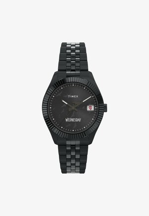 Černé metalové hodinky Timex s texturovaným černým ciferníkem, stříbrnými hodinovými indexy a ukazatelem dne se skull akcentem. Nastavitelný náramek.