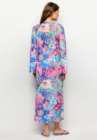 Lang jurk met een levendig oceaanthema print met schelpen en bloemen, in tinten van roze, blauw en groen; gemaakt van lichtgewicht stof.