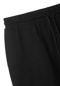 Pantaloni jogger neri con cintura elasticizzata e cordino, caratterizzati da una texture di tessuto liscia e tasche laterali.