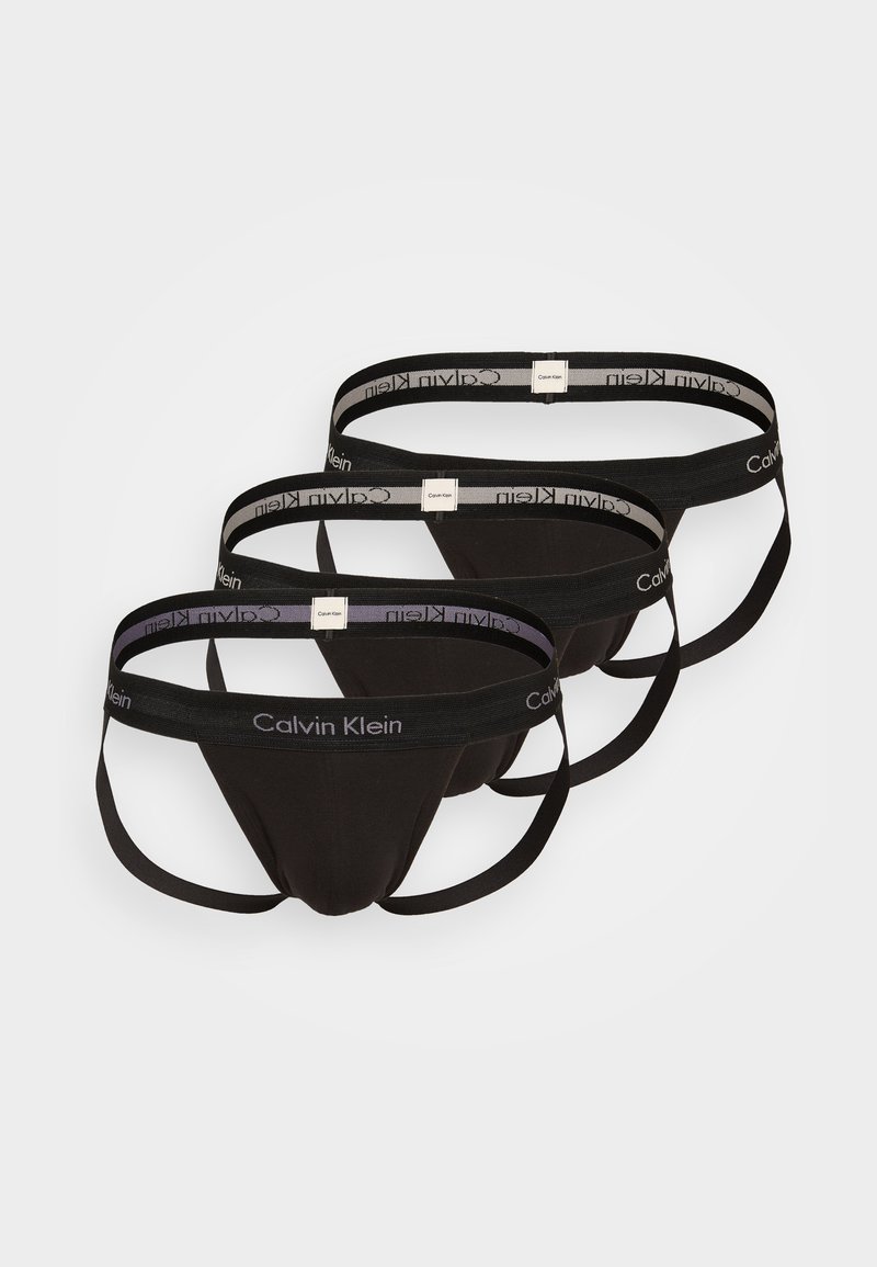 Drei schwarze Stringunterhosen mit elastischen Calvin Klein Markenbund, die aus glattem Stoff bestehen und ein konturiertes Design aufweisen.