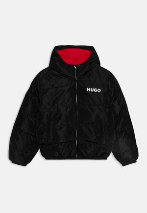 Veste en duvet noire avec fermeture éclair à l'avant, capuche et doublure intérieure rouge. Présente le logo blanc "HUGO" sur la poitrine et deux poches avant.