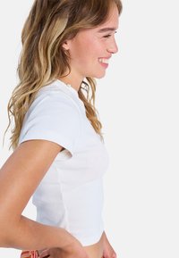 Witte aansluitende t-shirt met korte mouwen, gemaakt van gladde katoen, met een ronde halslijn en een licht cropped ontwerp.
