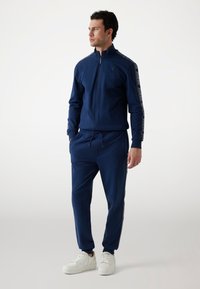 Guess JOGGING - Tracksuit bottoms - dunkelblau