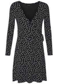 Svart omslagklänning med långa ärmar, har ett mönster med vita prickar, V-ringning och ett knytband i midjan för justerbar passform.