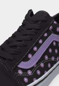 Mustad tennised mustade paeltega, millel on lillakate lillemustriliste tikanditega ja lavendelset lainelist triipu külje peal.