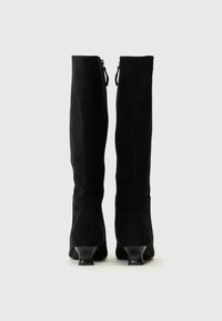 Botas negras hasta la rodilla hechas de ante con un diseño elegante, que cuentan con un pequeño tacón y cierre de cremallera en la parte posterior.