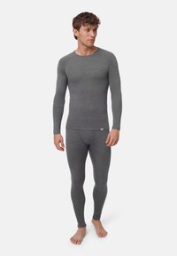Grau meliertes Thermo-Langarmshirt und Leggings mit geripptem Muster und figurbetontem Design, hergestellt aus weichem, dehnbarem Material.