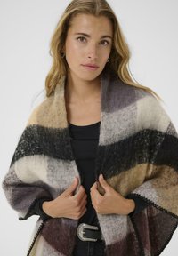 Multicolored striped shawl in soft wool blend, featuring shades of beige, brown, gray, and black, with a textured finish and scalloped edges.