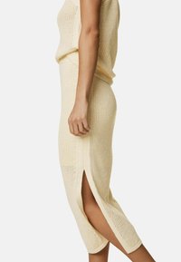 Strikket sweaterkjole i lys creme, med et tekstureret mønster, knælængde med sideslidser og en tætsiddende silhuet.