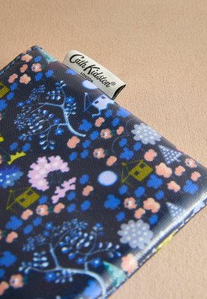 Portafoglio con motivo floreale realizzato in tessuto rivestito di blu scuro, con fiori rosa e blu, case verdi e un'etichetta bianca con logo.