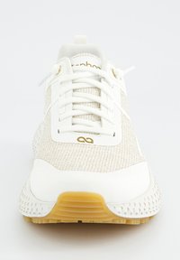 Chaussure de sport blanche avec une tige texturée, des accents dorés contrastants et un design de semelle à motifs pour une meilleure adhérence.