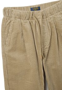 Beige corduroy broek met een ribbelstructuur, elastische tailleband, voorpijpen en trekkoord. Etiket zichtbaar: OVS kids.