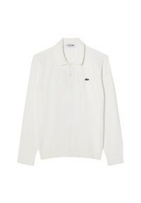 Polo a maniche lunghe bianco con colletto classico, caratterizzato da un piccolo logo verde Lacoste sulla parte sinistra del petto. Tessuto in cotone.