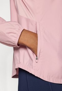 Ροζ ελαφρύ μπουφάν με ελαστικές μανσέτες, φερμουάρ σε πλαϊνή τσέπη και υφασμάτινη επιφάνεια με υφή. Μαλακό, απαλό ύφασμα με άνετη εφαρμογή.