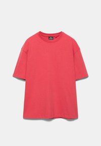 T-shirt oversize rouge à manches courtes en coton avec col rond, coupe ample et étiquette de marque visible à l'intérieur du col.