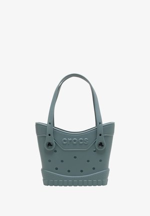 Sac fourre-tout en caoutchouc gris avec bords arrondis, grandes aérations et deux poignées. Présente le logo "croc" sur le devant.