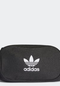 Mustapohjainen pussi, jossa on valkoinen Adidas-logo kolmonenlehvellä, vetoketjukiinnityksellä ja tekstuuripinnalla. Kompakti ja suorakulmainen muoto.