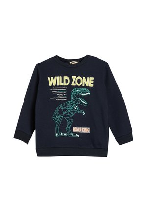 Sudadera azul marino con puños y dobladillo acanalados. Presenta un gráfico geométrico de dinosaurio y el texto "ZONA SALVAJE" en amarillo claro.