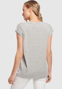 Graues Kurzarm-T-Shirt, weiche Baumwollmischung, leicht verlängter Saum hinten, gerollte Ärmel, lässige Passform, einfarbige Textur.