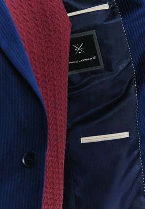 Granatowa marynarka z bordo teksturowanym podszewką; oferuje gładki materiał, białe przeszycia i metkę z napisem "Pako Lorente." Szczegóły wewnętrznej kieszeni.