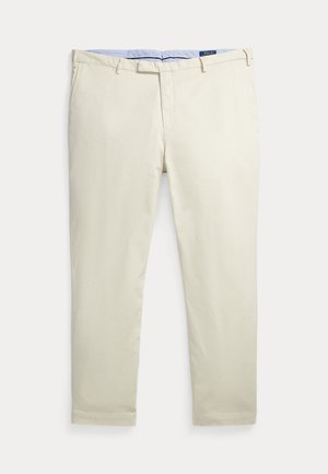 Pantalones beige ajustados de hombre con trabillas para cinturón, bolsillos delanteros, cremallera y una etiqueta de la marca Polo en el interior de la pretina.