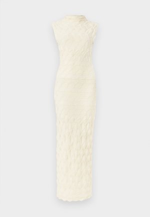 Kreemivärvi varrukateta maksikleit kõrge kaeluse ja tekstiilil lainelise mustriga, taustaks valge.