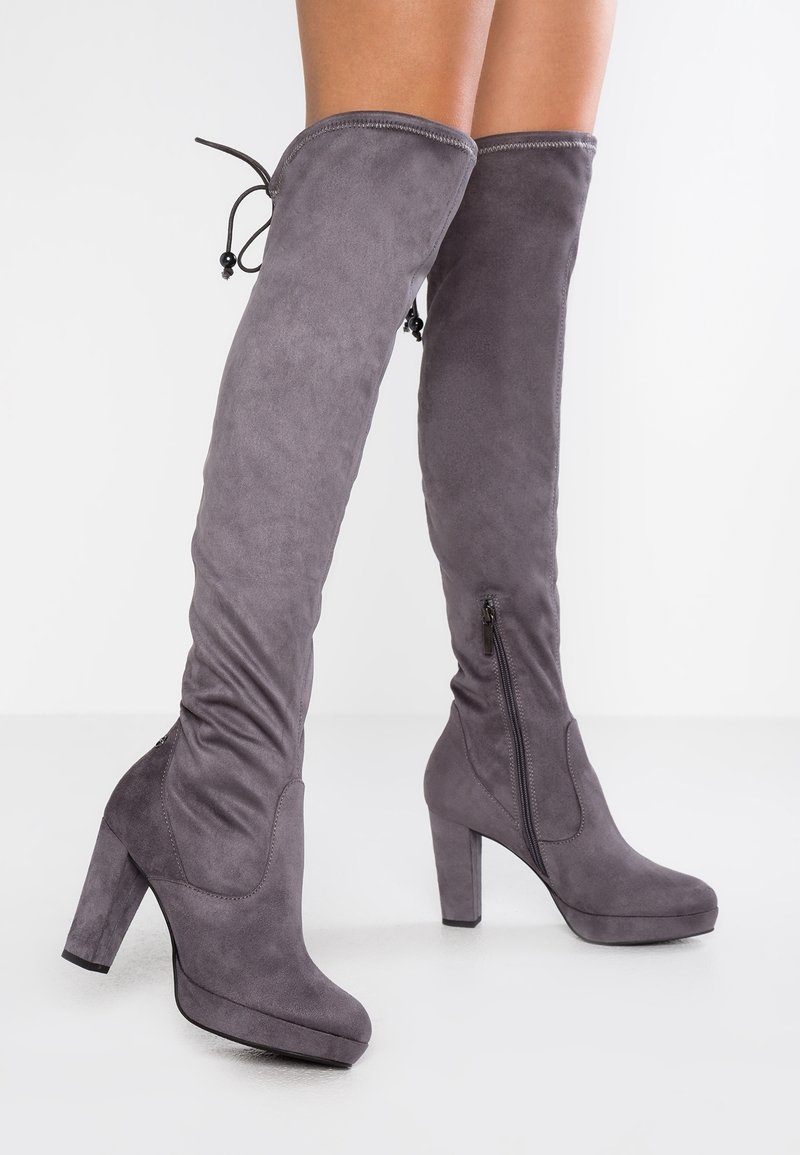 Bottes grises en daim au-dessus du genou avec un talon bloc haut, dotées d'une fermeture éclair latérale et d'un cordon ajustable à la manchette.
