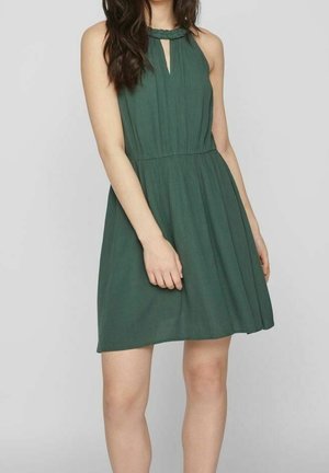 Vihreä, hihaton mekko, jossa on avainreikäkaula-aukko ja laskostettu rakenne. Kangas on kevyt ja laskeutuu pehmeästi vyötäröltä.