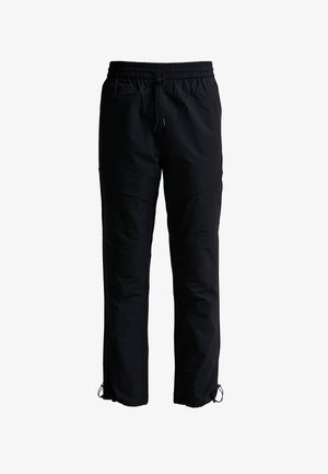 Pantalon noir décontracté avec taille élastique et cordons à la taille et aux chevilles, coupe droite, sans logos ni motifs visibles.