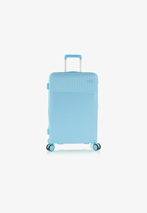 Light blue hard-shell suitcase with vertical ridges, silver telescopic handle, and 4 multi-directional wheels, featuring black accents.