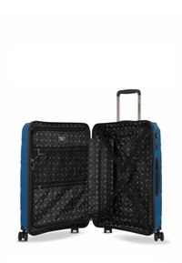 Blaue Hartschalenreisetasche geöffnet, zeigt schwarzes Innenleben mit Reißverschlussfächern, Kreuzgurt, ausziehbarem Griff und vier drehbaren Rollen.