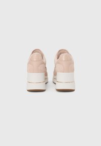 Baskets en daim rose avec un dos en peluche, semelle blanche superposée avec un accent doré, et forme arrondie. Design minimaliste adapté à une tenue décontractée.