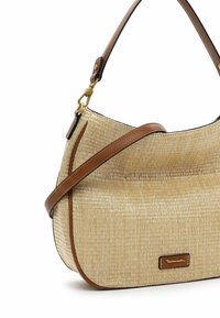 Sac à main en paille beige, avec une forme arrondie, des accents en cuir marron et un détail en métal doré arborant un logo. Bandoulière ajustable incluse.