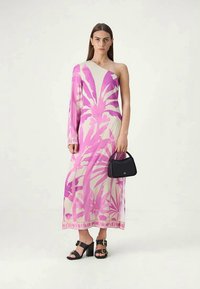 Vestido maxi de un solo hombro en beige claro con estampado de hojas tropicales rosas de gran tamaño y dobladillo de encaje. Combinado con un pequeño bolso negro y tacones gruesos.