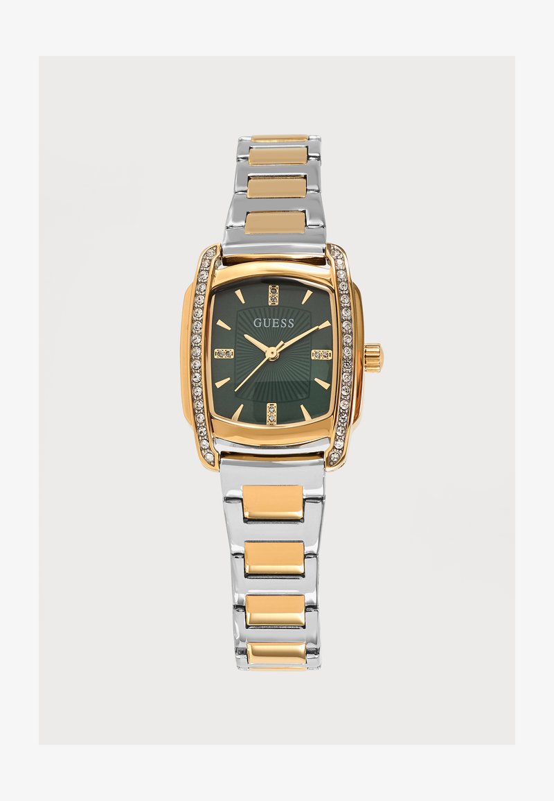Montre-bracelet bicolore argent et or avec cadran carré vert, marqueurs dorés, accents en cristal et bracelet à maillons en métal. Nom de la marque GUESS sur le cadran.