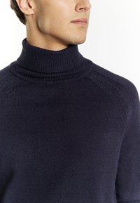 Maglione a collo alto blu navy, texture a coste, design aderente, con dettagli sottili sulle spalle, realizzato in morbido filato.