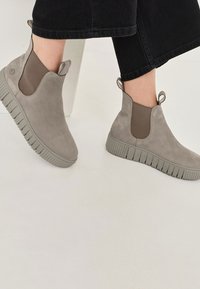 Grijze suède enkelschoenen met elastische zijkanten, getextureerde rubberen zolen en achterste treklussen voor gemakkelijk aan- en uittrekken. Gladde afwerking en een minimalistisch ontwerp.