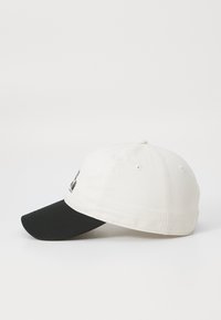Cappellino da baseball con corpo in cotone bianco e visiera nera. La parte anteriore presenta un ricamo multicolore. Design a sei pannelli con fori di aerazione.