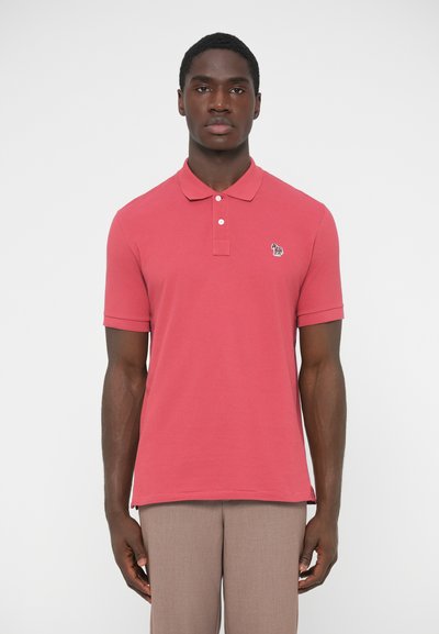 Polo rose à manches courtes avec col à trois boutons et logo brodé sur la poitrine gauche. Tissu en coton lisse et coupe ajustée.