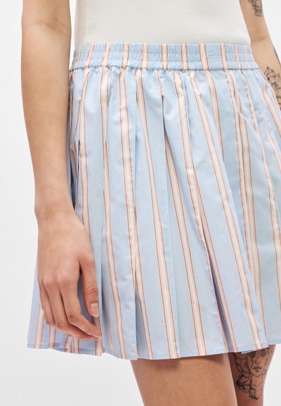 Jupe plissée bleu clair avec des rayures verticales en corail et blanc. Taille élastique et texture de tissu lisse et brillante.