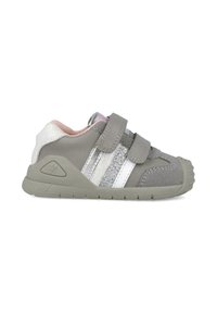 Zapatillas grises para niños pequeños con dobles correas de Velcro, acentos de purpurina plateada y una suela exterior texturizada y flexible. Interior suave y acolchado con un talón brillante.